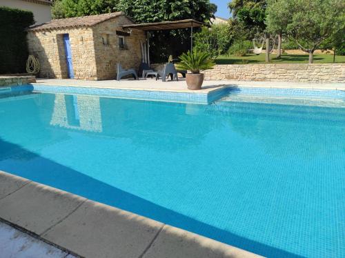 une grande piscine bleue avec une table et des chaises dans l'établissement GITE L'ATELIER, à Palus