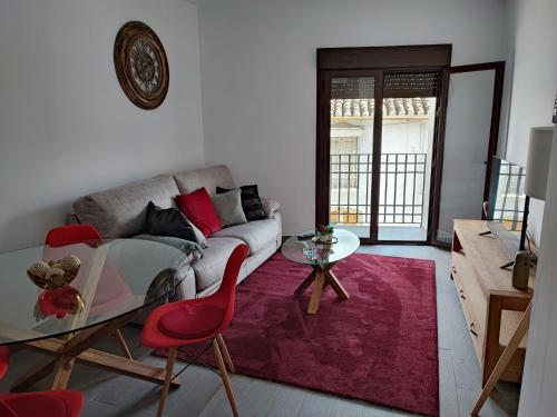 uma sala de estar com um sofá e uma mesa de vidro em La Medina Alta em Setenil de las Bodegas