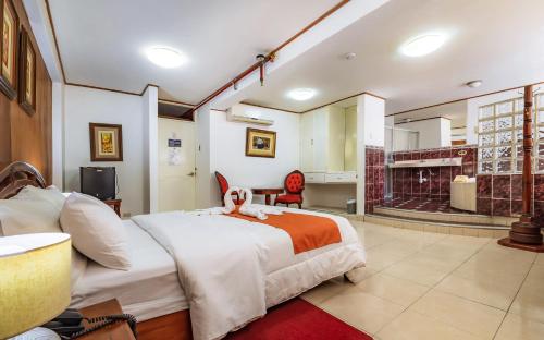 a bedroom with a large bed and a kitchen at Recreo Hotel in Trujillo