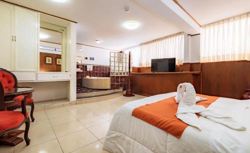 a hotel room with a bed and a tv at Recreo Hotel in Trujillo