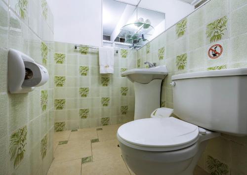 a bathroom with a toilet and a sink at Recreo Hotel in Trujillo
