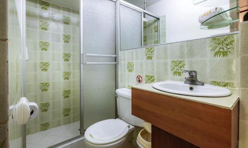 a bathroom with a toilet and a sink and a shower at Recreo Hotel in Trujillo