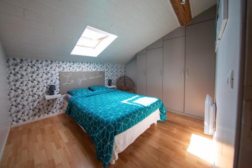 Schlafzimmer mit einem Bett mit blauer Decke in der Unterkunft Gîte des lacs in Meussia