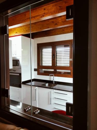 a kitchen with a sink and a glass wall at Casa Rural Tejedor in Morillo de Monclús