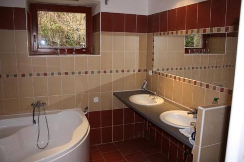 a bathroom with two sinks and a bath tub at Chalupa U Effoucha in Lipno nad Vltavou