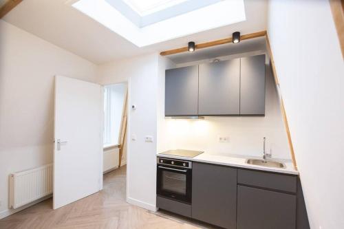 Il comprend une cuisine avec un évier et une lucarne. dans l'établissement Appartement in binnenstad/centrum van Leeuwarden, à Leeuwarden