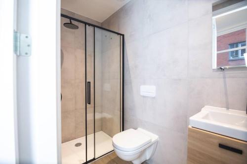 uma casa de banho com um chuveiro, um WC e um lavatório. em Appartement in binnenstad/centrum van Leeuwarden em Leeuwarden