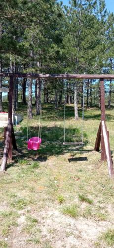 a playground with a pink swing in a park at Ruza vetrova in Divčibare