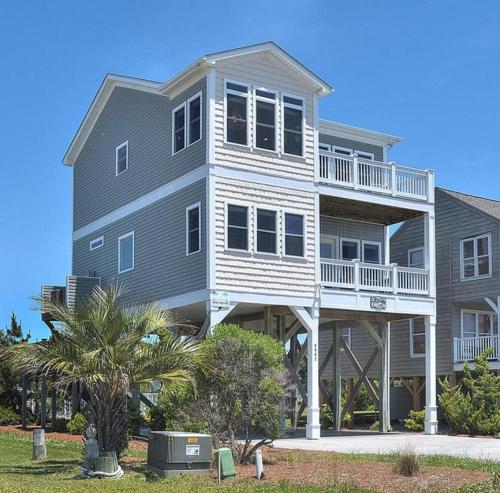 a large house with a balcony on the side of it at 1 More Day in Oak Island