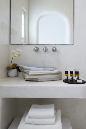 a bathroom with a sink and a mirror and towels at Olia Villa in Imerovigli