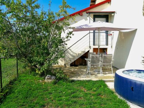 a patio with an umbrella and a table and chairs at Gîte des lacs in Meussia
