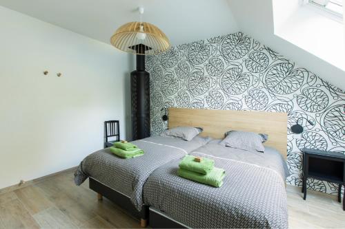 1 dormitorio con 1 cama y 2 toallas verdes en Aux Bois Dorés de la Ferme de sorval, animaux de la ferme, fitness, en Selvigny
