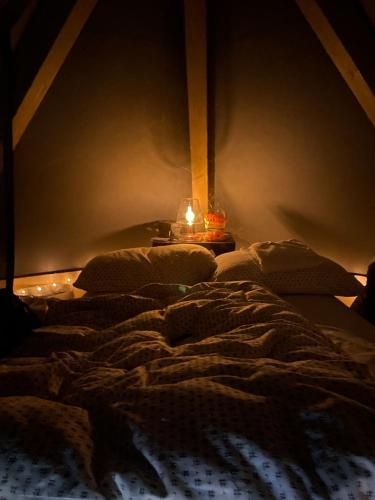 a dark room with an unmade bed with a candle at Tipì in Chiusanico