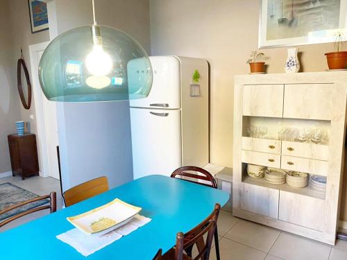 a kitchen with a blue table and a refrigerator at Casa Milvio a Marina di Cecina by Zoom In Earth in Marina di Cecina