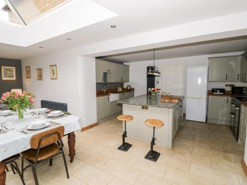 a kitchen and dining room with a table and chairs at Rosemead in Moreton in Marsh