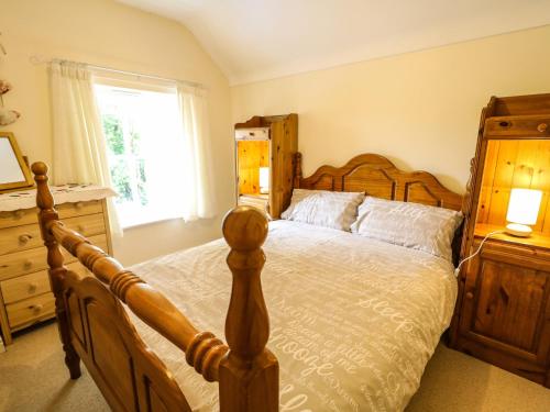 a bedroom with a wooden bed and a window at Sarah Magees in Enniskillen