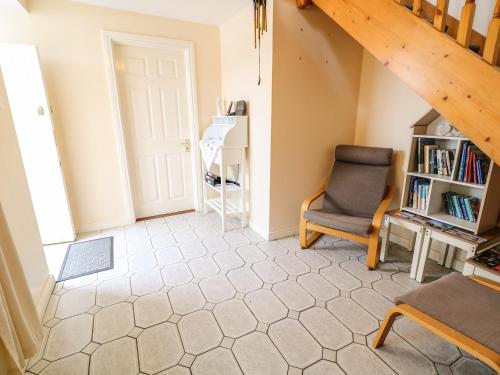an attic room with a chair and a book shelf at Sarah Magees in Enniskillen