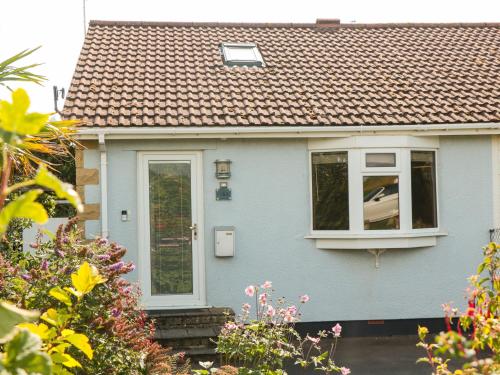 a blue house with a window and a roof at Tillys Cottage in Weston-super-Mare