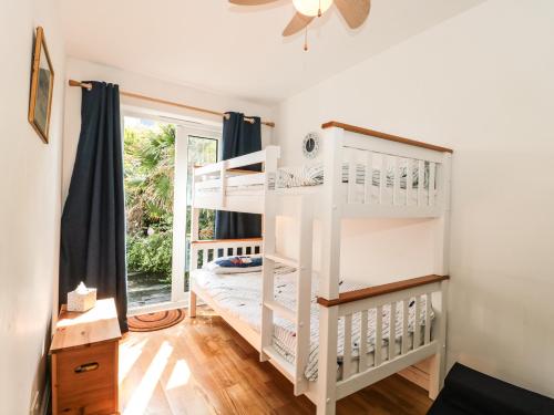 a white bunk bed in a room with a window at Tillys Cottage in Weston-super-Mare
