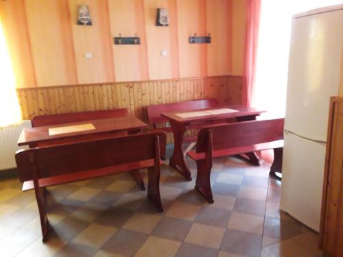 a dining room with two tables and a refrigerator at Evita Vendégház in Sajókápolna