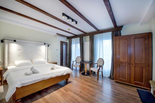 a bedroom with a bed and a table and chairs at Old Town Cataleya in Sibiu