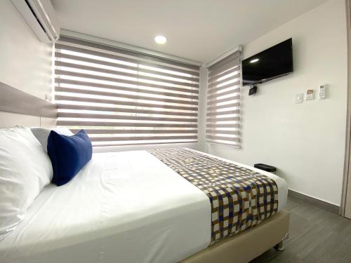 a bedroom with a large bed and a television at Seven Inn Hotel in Medellín