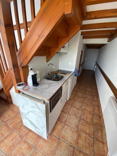 une cuisine avec un évier et un plan de travail dans l'établissement Maison de la mer, à Hendaye