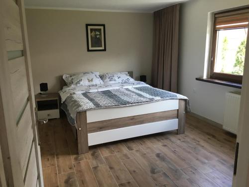 Schlafzimmer mit einem Bett und Holzboden in der Unterkunft BALTIC VIBES APARTAMENT in Kołobrzeg