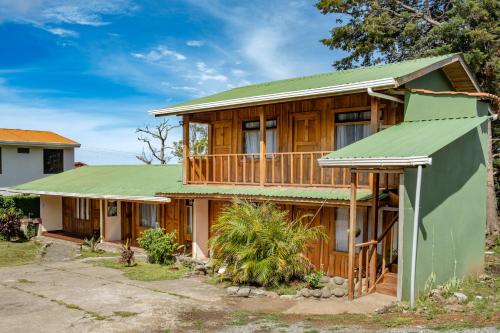 a wooden house with a green roof at Cowboy Hostel - Habitaciones con Baño Privado in Monteverde Costa Rica