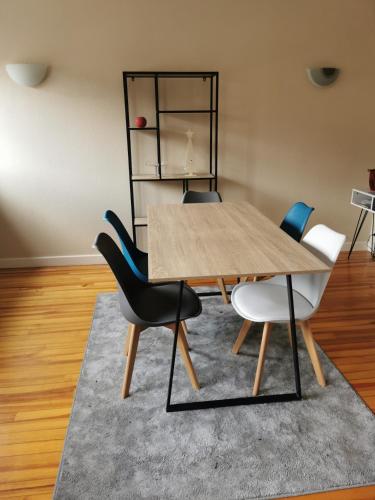 une salle à manger avec une table et des chaises en bois dans l'établissement Chambre privée dans appart partagé, centre ville, avec vue sur les monuments, au Puy-en-Velay