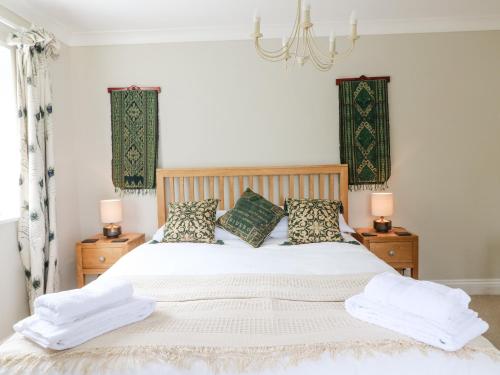 sypialnia z łóżkiem z białą pościelą i poduszkami w obiekcie Little Orchard w mieście Dorchester