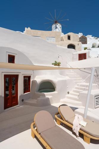 a pair of chairs on a balcony of a house at The Architect's Cave House in Oia