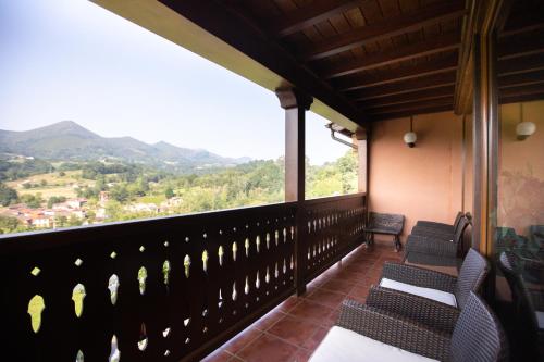 a balcony with chairs and a view of the mountains at Hotel & Spa Villa de Mestas in Cangas de Onís