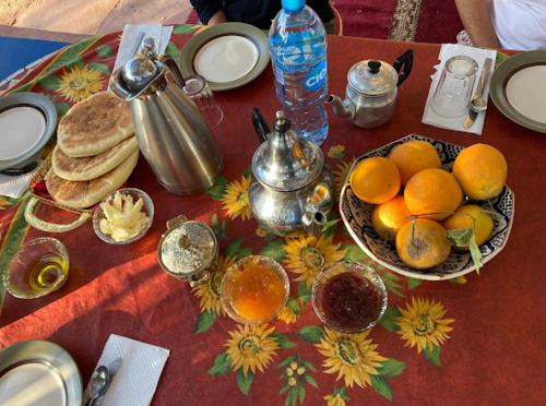 einen Tisch mit einem Teller Orangen und Pfannkuchen in der Unterkunft Afoulki Ecotourism Guest House in Telouet
