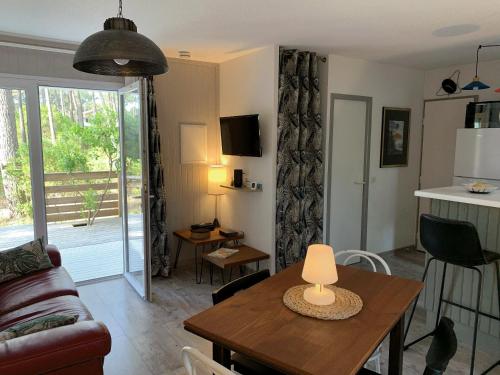 - un salon avec une table et une lampe dans l'établissement Chalet Mavalear naturiste La Jenny, à Le Porge