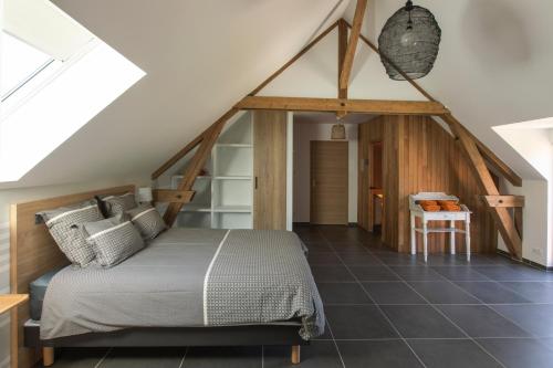 a bedroom with a bed in a attic at Aux Petits Lapins de Sorval, sauna privé, fitness in Selvigny