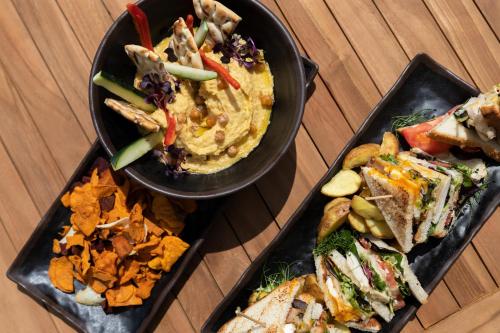two plates of food on a table with sandwiches and dips at Sol House The Studio - Calviá Beach - Adults Only in Magaluf