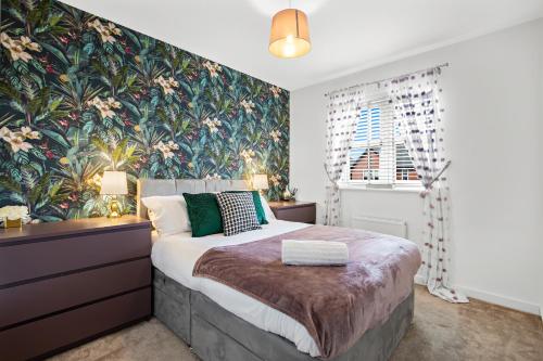 a bedroom with a large bed with a floral wallpaper at Silver Stag Properties, 3 bedroom luxury house in Coalville