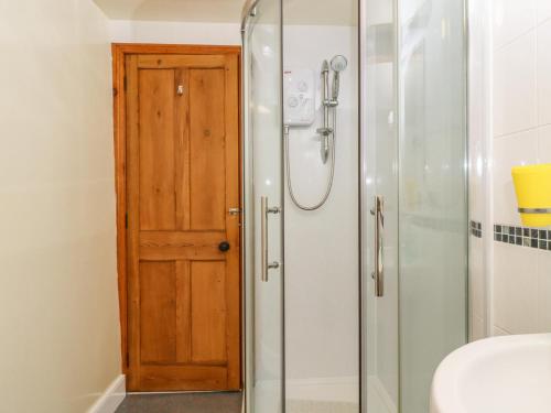 a bathroom with a shower and a wooden door at 2 The Square in Skipton
