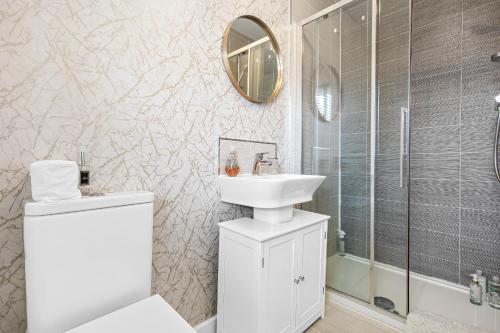 a white bathroom with a sink and a shower at Silver Stag Properties, 3 bedroom luxury house in Coalville