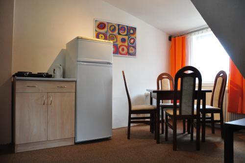 Il comprend une cuisine équipée d'un réfrigérateur et d'une table avec des chaises. dans l'établissement Hostel Pestalozza, à Špindlerův Mlýn