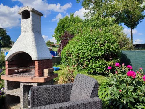 a brick oven sitting next to a chair in a garden at Vakantiestudio Ciney in Chapois