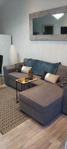 un salon avec un canapé et une table dans l'établissement Gîte le jardin d eau, à Lamothe-Montravel