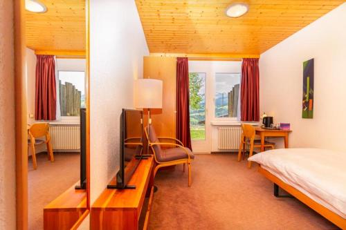 um quarto com uma cama e uma televisão num quarto em Hotel Swiss Views em Hemberg