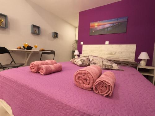 a purple bed with pink towels on top of it at MEMORIA in Corfu Town