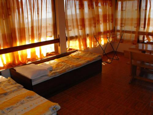 a bedroom with two beds and a window with curtains at Къща за гости Костови in Byala