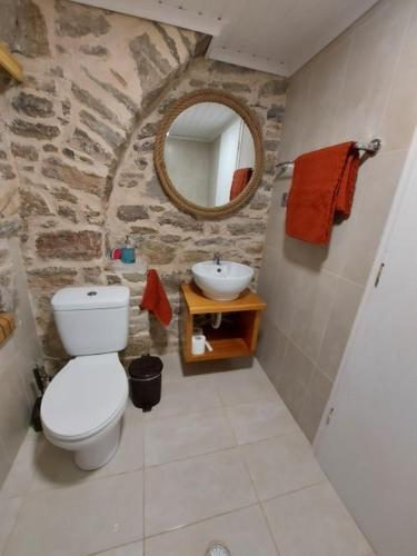 a stone bathroom with a toilet and a sink at Ήλιος Πατσακης in Symi