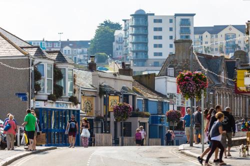 a group of people walking down a street with buildings at Newquay Horizons in Newquay
