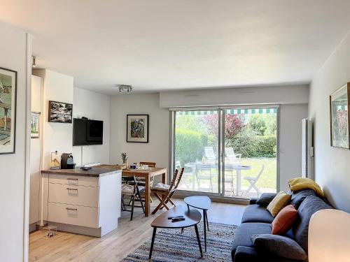 un salon avec un canapé et une cuisine avec une table dans l'établissement Zéllie - YourHostHelper, à Deauville