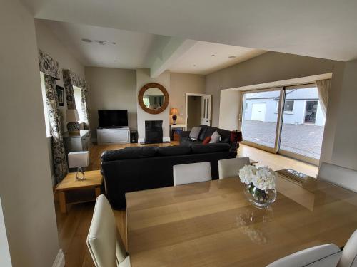 a living room with a black couch and a table at The Coach House in Dublin
